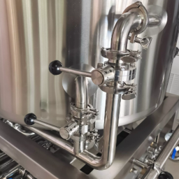 Stainless steel piping and fittings connected to a brewing vessel.