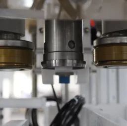 Close-up of mechanical components with silver and gold fittings in an industrial setting.