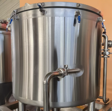 Stainless steel brewing tank with valves and fittings.