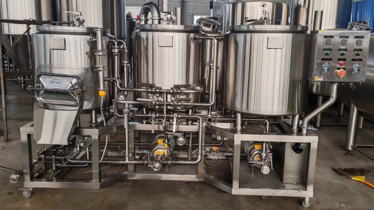 Stainless steel processing equipment with multiple tanks and a control panel.