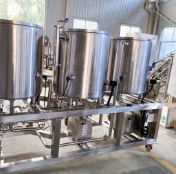 Stainless steel brewing equipment with three tanks on a wheeled frame.