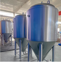 Three metallic fermentation tanks in a industrial setting.