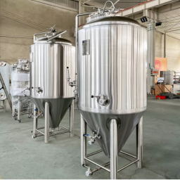 Shiny stainless steel brewing tanks with valves and pipes.