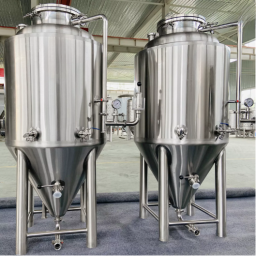 Two stainless steel fermentation tanks side by side in a brewery setting.
