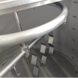 A close-up of stainless steel equipment with a rotating arm and measuring markings.