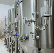Shiny stainless steel fermentation tanks in a brewery setting.