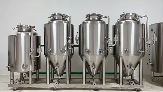 Three stainless steel fermentation tanks in a row, varying in size.
